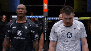 two men standing next to each other with one wearing a shirt that says ufc