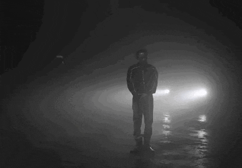 a man in a gas mask stands in the dark