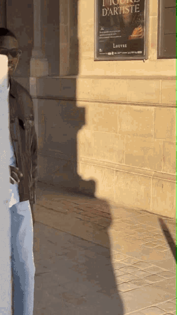 a man standing in front of a sign that says louvre on it