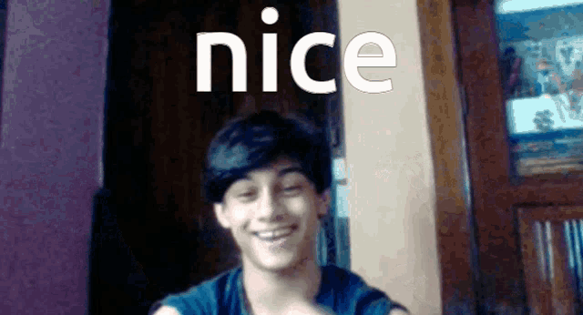 a young boy smiles in front of a nice sign
