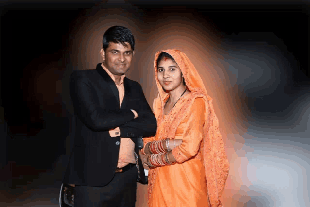 a man and a woman pose for a picture with their arms crossed