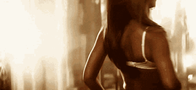 a woman in a bra is standing in a room