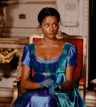 a woman in a blue dress and blue gloves is sitting in a chair with mistressvera tumblr written below her