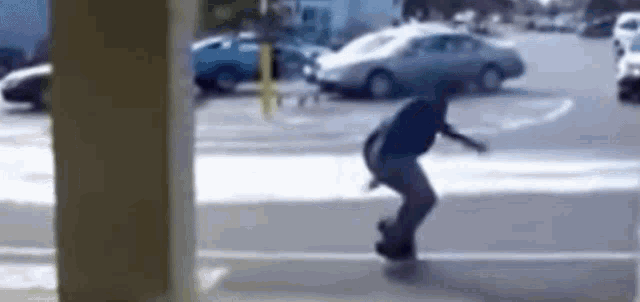 a man is riding a skateboard on a sidewalk in a parking lot .