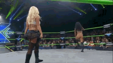 two women are wrestling in a ring with the word impact on the wall behind them