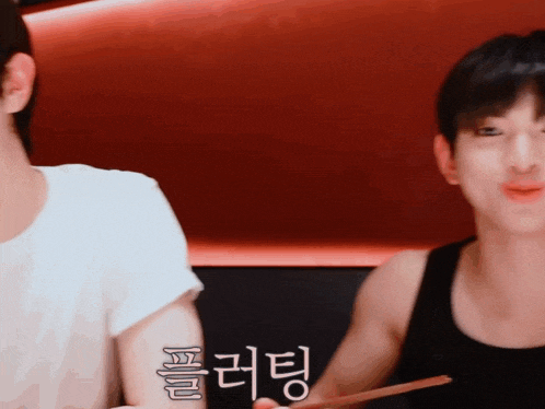 two men are sitting next to each other and one has a tattoo on his arm that says ' a '