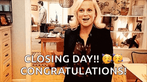 a woman is standing in a living room with the words `` closing day ! congratulations ! '' written on her face .