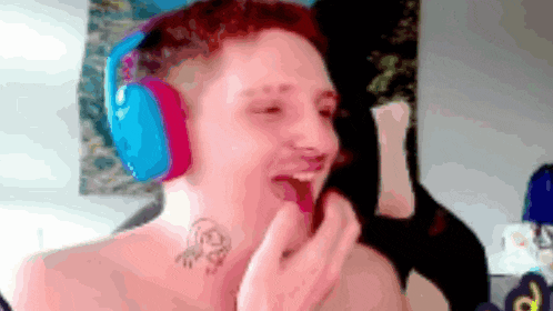 a shirtless man wearing headphones and a tattoo on his neck .