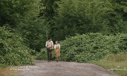 a man and woman walking down a dirt road with the words " when calls the heart " written on the bottom