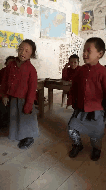 children in a classroom with a poster on the wall that says rose