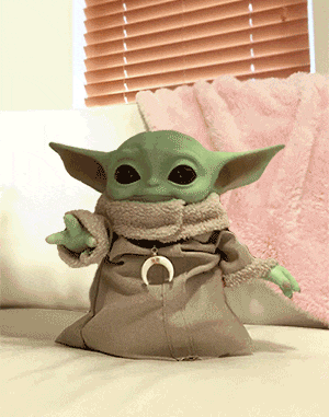 a baby yoda doll is sitting on a couch