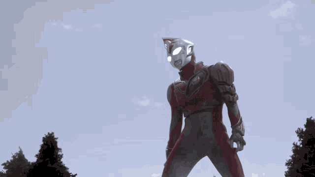 a cartoon character in a red and silver suit with a red emblem on his chest