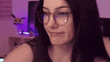 a woman wearing glasses is making a face in front of a computer monitor