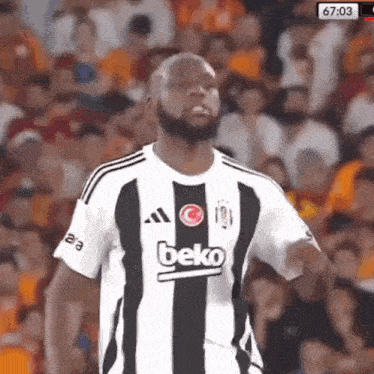 a man with a beard is wearing a black and white striped beko jersey .