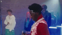 a man in a red jacket is standing in front of a crowd of people .