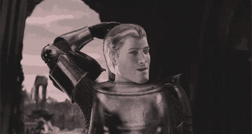 a woman is wearing a knight 's armor in a black and white photo .
