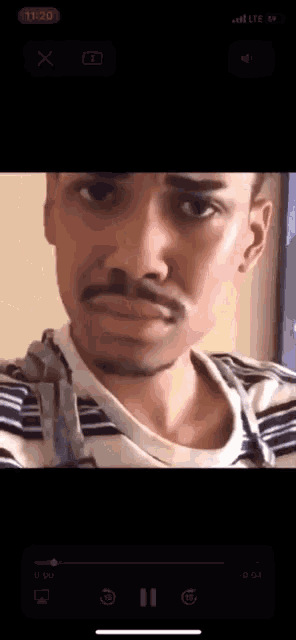 a video of a man with a mustache is being played on a cell phone
