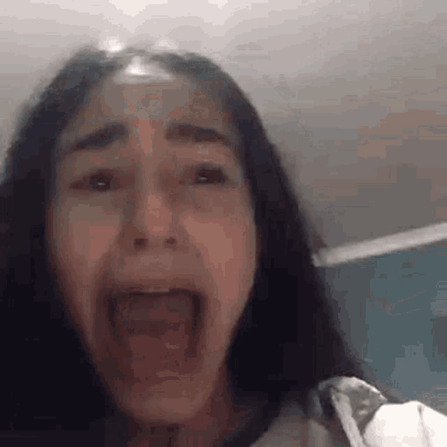 a girl is making a funny face with her mouth wide open .
