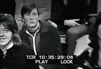 a black and white photo of a group of people sitting in a room with a time stamp that says tcr 10:35:29 .