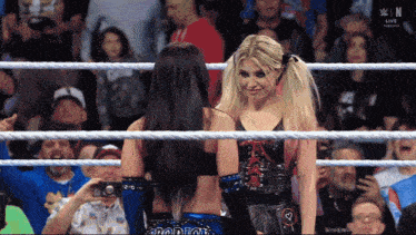 two women in a wrestling ring with the word win on the bottom left