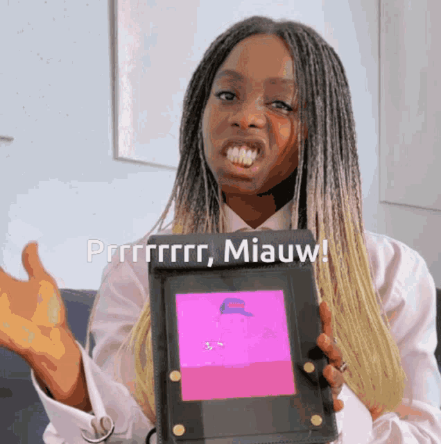 a woman is holding a tablet that says prrrrrr miauw on the bottom