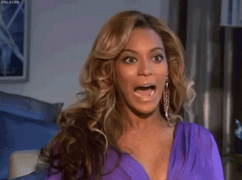a woman in a purple dress is making a funny face with her hands .