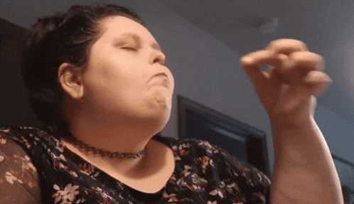 a woman wearing a choker and a floral shirt is eating something