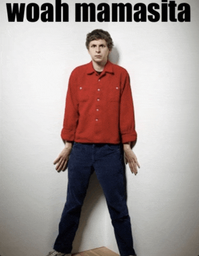 a man in a red shirt is standing in front of a white wall with the words woah mamasita written above him