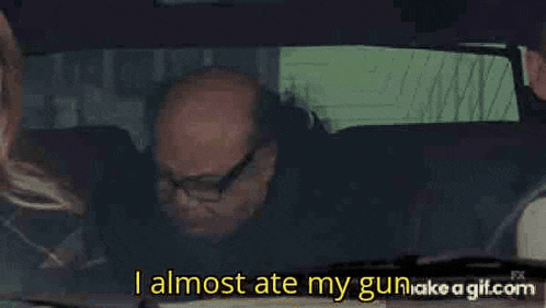 a man is sitting in a car eating a sandwich and drinking a bottle of beer .