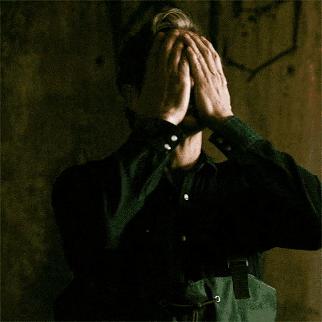 a man with a mustache is wearing a black shirt