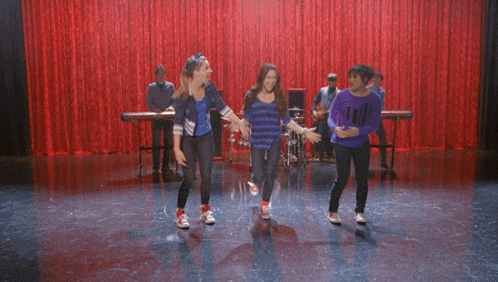 a group of girls are dancing in an auditorium