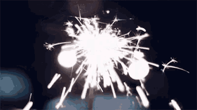a close up of a sparkler on a stick in the dark .