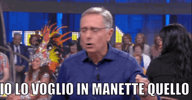 a man in a blue shirt says io lo voglio in manette quello in front of a crowd of people