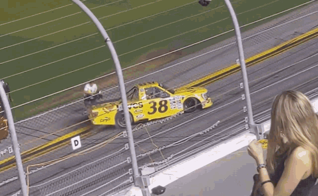 a yellow race car has the number 38 on the side