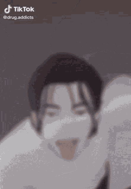 a blurred image of a person with their tongue out and a tik tok watermark