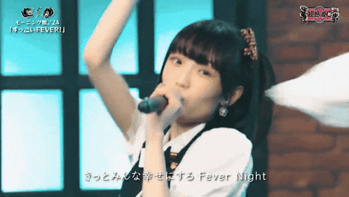 a girl singing into a microphone with the words fever night written below her