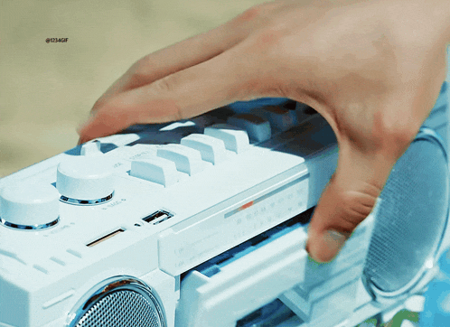 a close up of a person 's hand touching a white radio