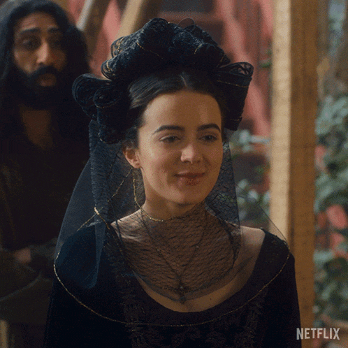 a woman with a veil on her head is smiling in front of a netflix sign