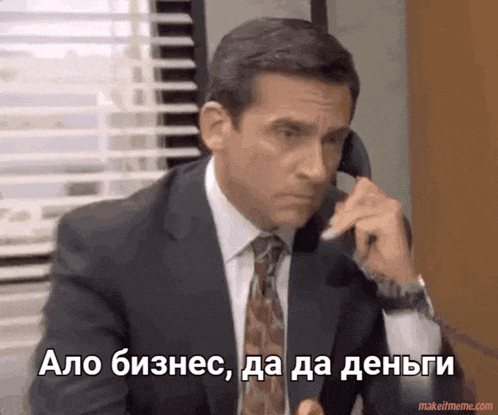 a man in a suit and tie is talking on a phone in a foreign language with makeitmeme.com at the bottom
