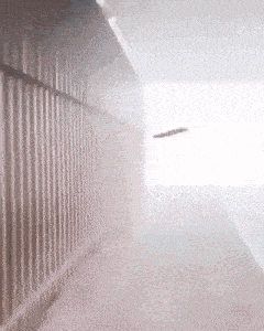 a blurred image of a building with a fence and a light
