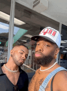 two men are posing for a picture and one has a hat that says chicago bulls