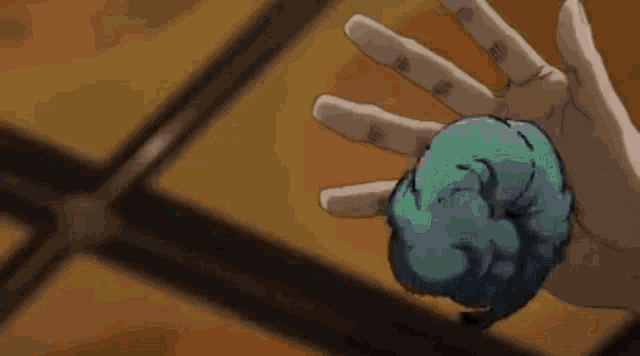 a close up of a person 's hand holding a piece of paper on a table .