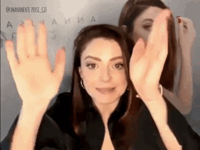 a woman is making a funny face with her hands up .