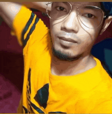 a young man wearing glasses and a yellow adidas shirt is taking a selfie .