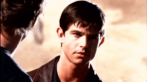 a close up of a man 's face with another man behind him