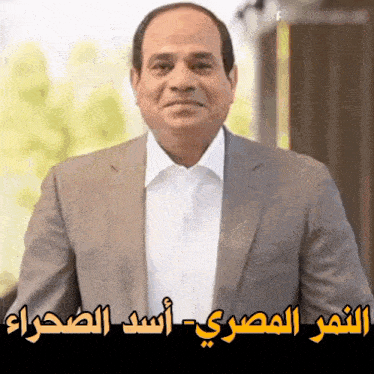 a man in a suit and white shirt with arabic writing