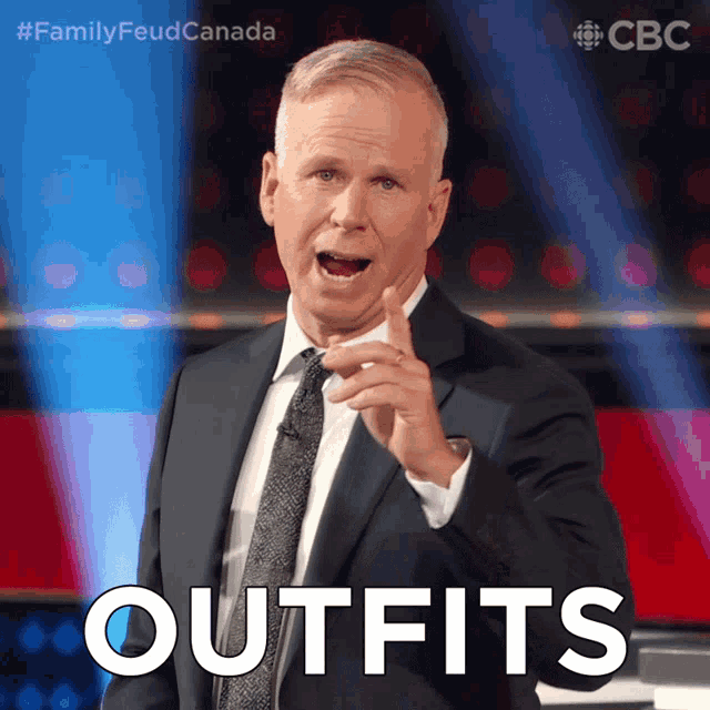 a man in a suit and tie says " outfits " while pointing