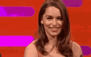 a close up of a woman 's face with a purple and orange background .