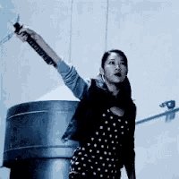 a woman in a polka dot dress holding a sword