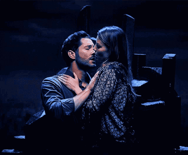 a man and a woman kissing in a dark room